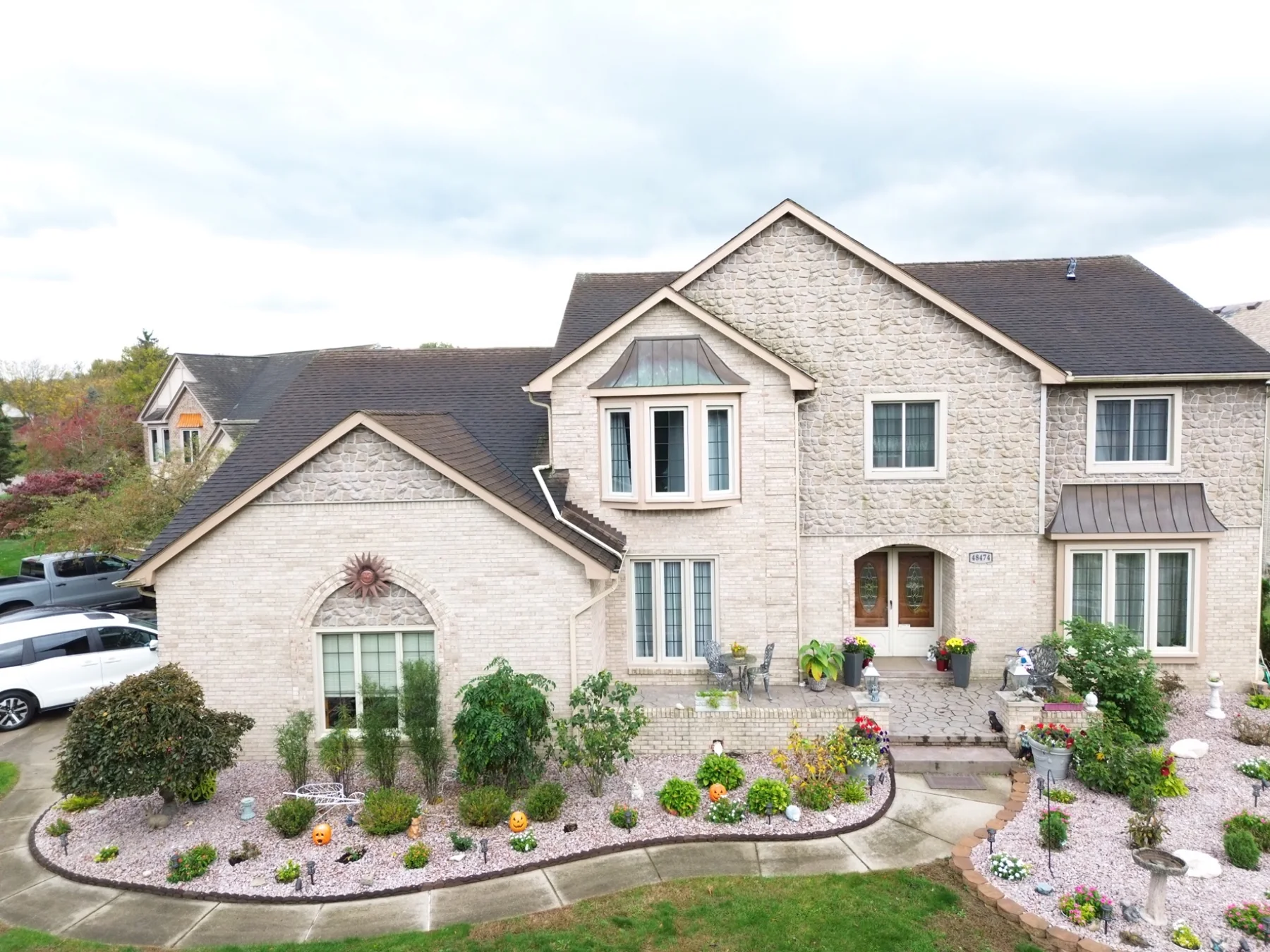 Closer aerial view of stone-front house and exterior features